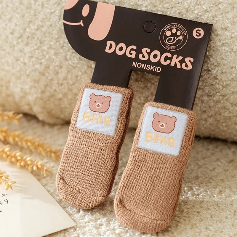 Dog wearing green non-slip socks with cartoon big eyes pattern on wooden floor