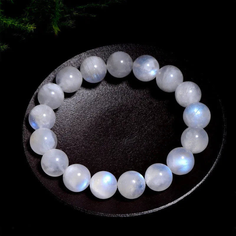 Natural blue moonlight round moonstone bead bracelet on a wrist, showing polished gemstone surface.