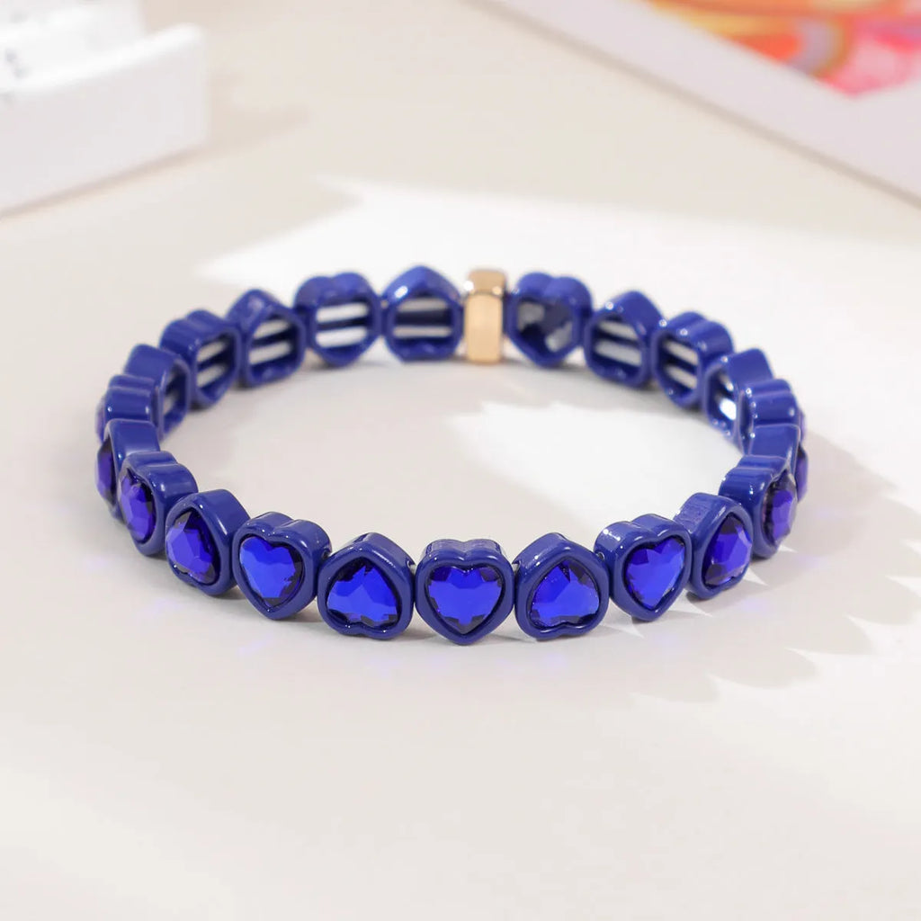 Rainbow enamel heart pendant on a stretch alloy bracelet, shown in multiple colour options.