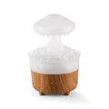 Wood grain white rain cloud shaped humidifier, diffuser, and night light on a table.