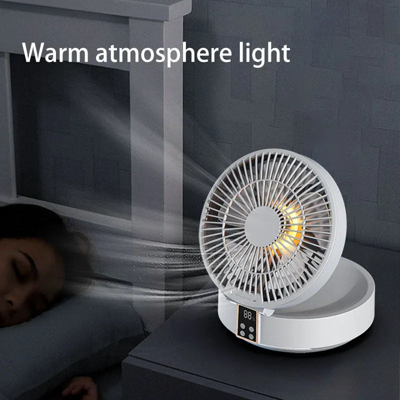 White rechargeable USB ceiling fan with remote control folded on a desk next to its charging cable.