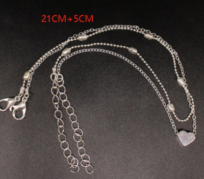 Double-layered heart-shaped anklet with retro beach-inspired chain in gold and silver colors