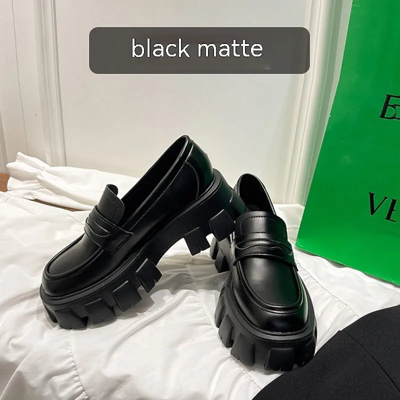 A pair of British style wide fit loafers in patent leather with a rubber sole.