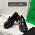 A pair of British style wide fit loafers in patent leather with a rubber sole.