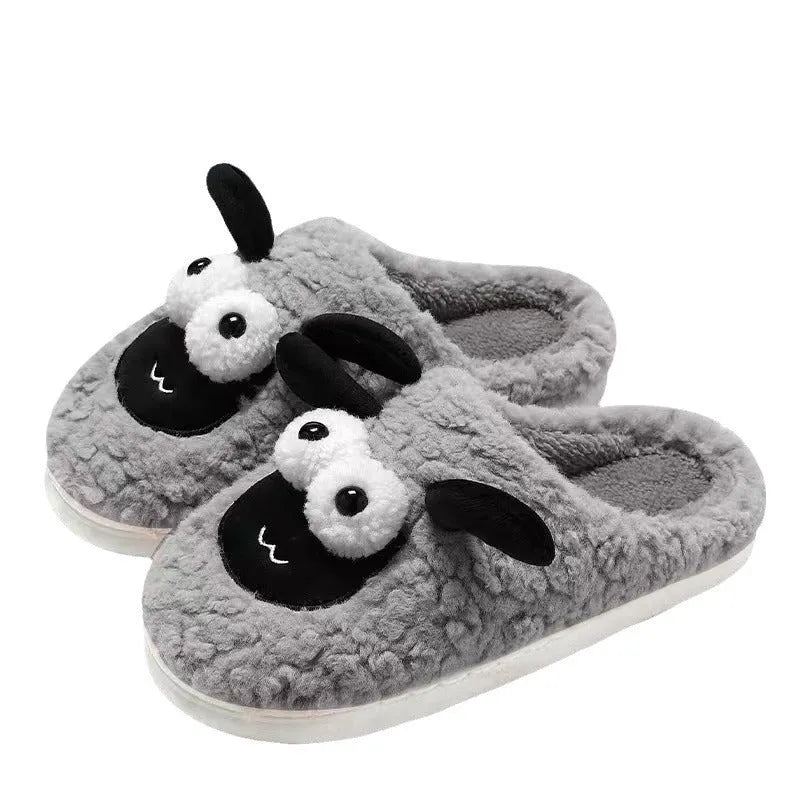 Brown unisex slip-on slippers with suede upper and light sole on a wooden floor.
