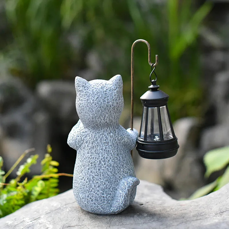 Solar garden light shaped like a kitten lifting a lamp, made from resin for outdoor decoration.