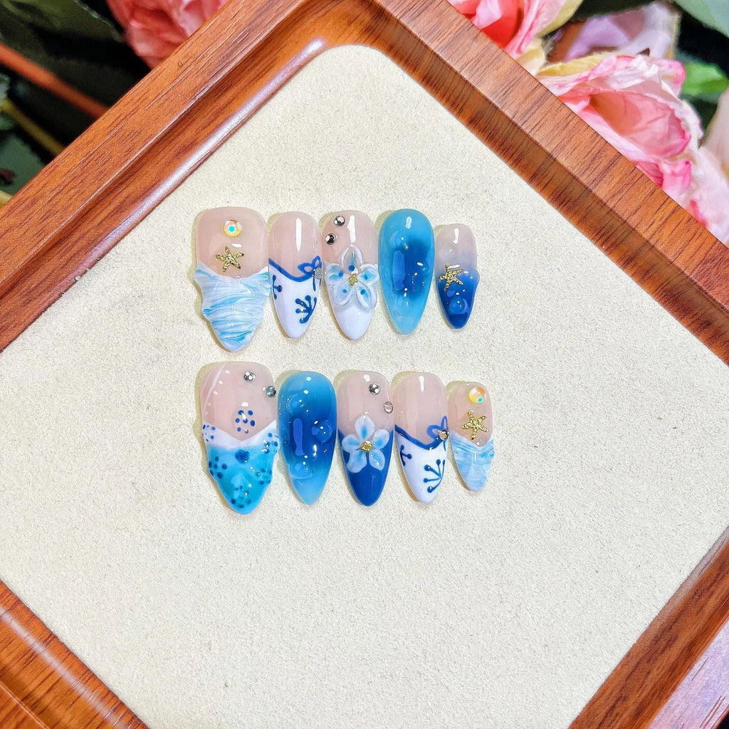 Blue carved designs on transparent fake nails showing summer ice aesthetic