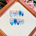 Blue carved designs on transparent fake nails showing summer ice aesthetic
