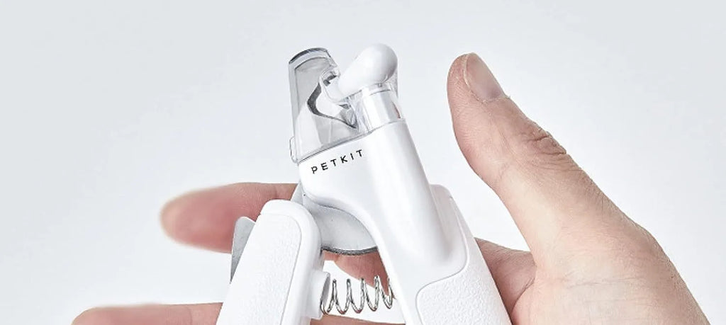 White LED pet nail clippers with a transparent anti-splash guard and an integrated nail file on a grey background.