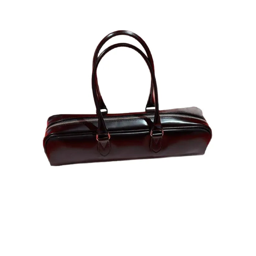 Black corduroy cowhide french stick underarm bag with sewing thread detail on a white background