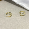 Four pairs of round buckle earrings in gold and silver metal finish on white background