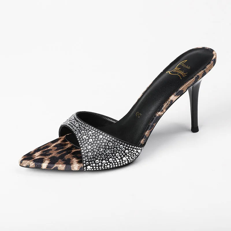 Black women's pointed-toe rhinestone sandals with a stiletto heel on a rubber sole.