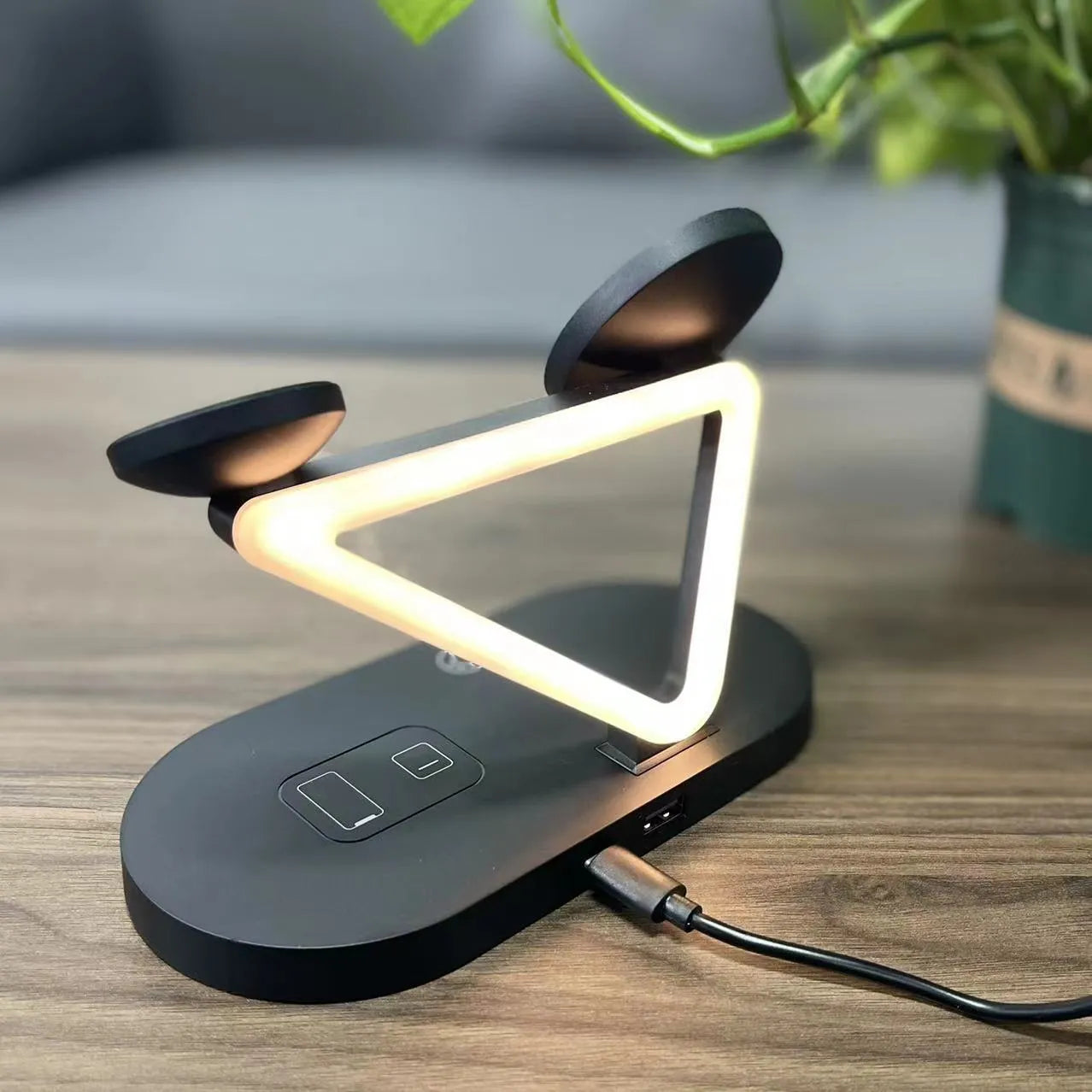 Black wireless charging station showing an iPhone, Apple Watch, and AirPods charging simultaneously on magnetic pads.