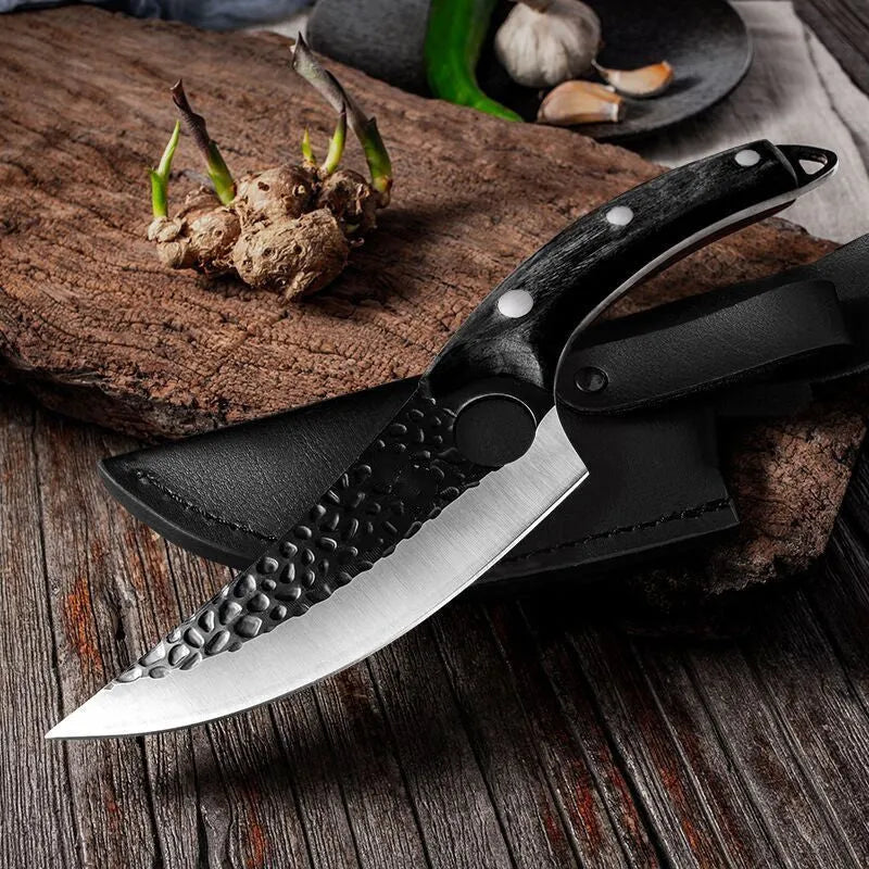 Small scimitar boning knife with hammer pattern finish and black leather sheath on surface