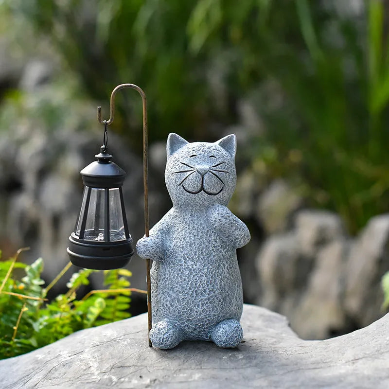 Solar garden light shaped like a kitten lifting a lamp, made from resin for outdoor decoration.