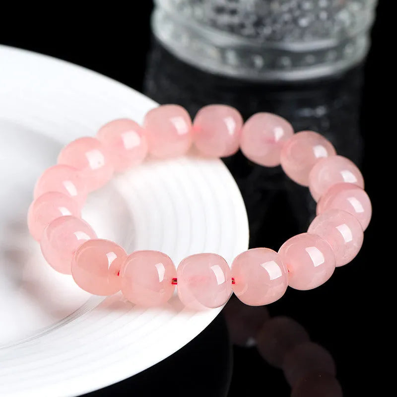 Natural pink crystal barrel bead bracelet with geometric design on wrist
