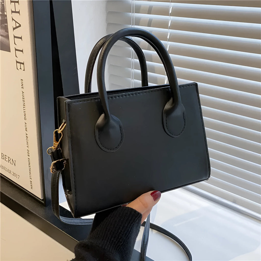 Small square shoulder bag in PU leather with single strap and document pocket, shown in available colours