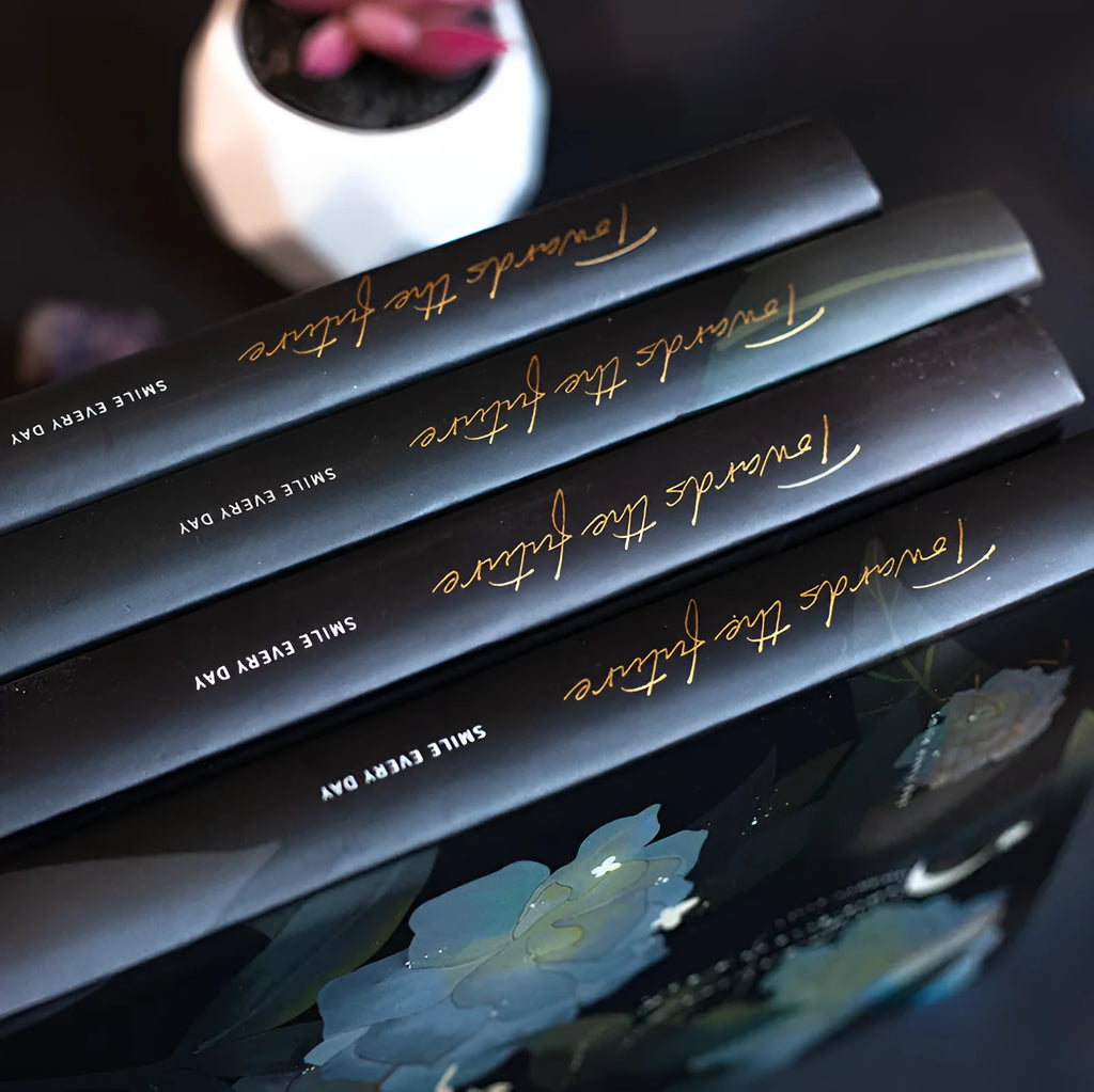 A5 notebook with a luminous cover open to show pages with colour illustrations.