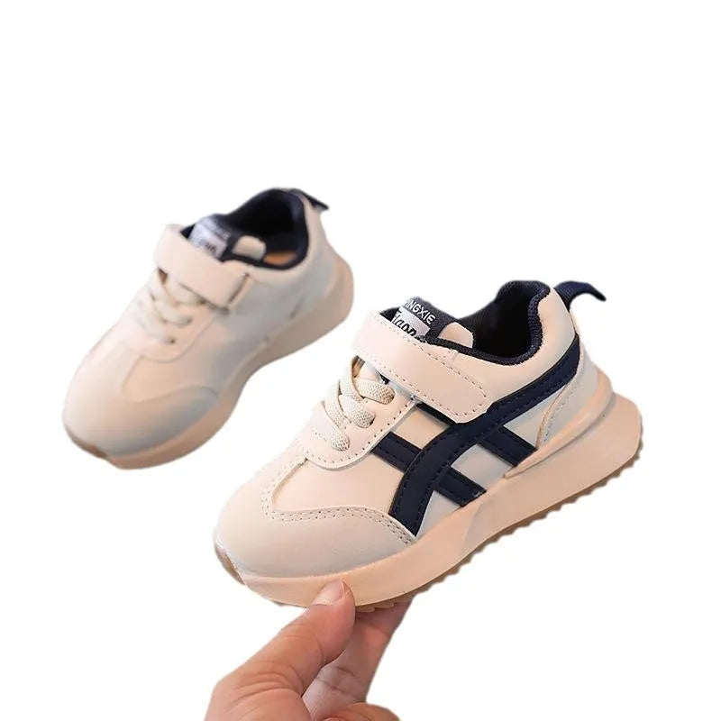 Children's white synthetic leather sneakers with Velcro fastening and textured rubber sole.