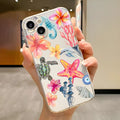 Clear transparent iPhone case with printed blue dolphin, green turtle, shell, and leaf designs.
