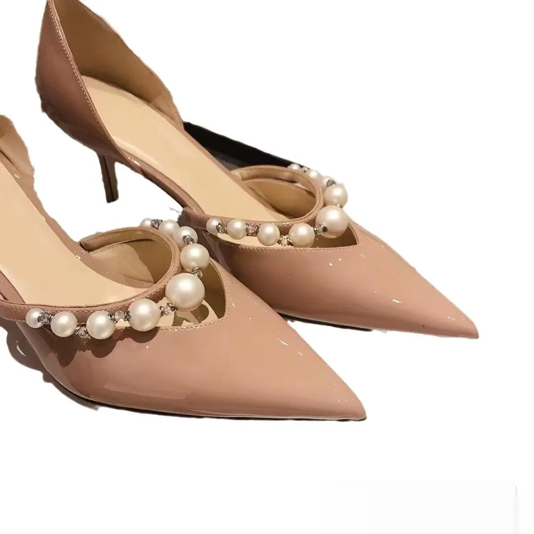 Women's black patent leather pointed stiletto heels with pearl decoration on the upper.
