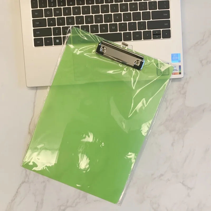 Transparent A4 clipboard with metal clip, shown in blue colour on a wooden desk.