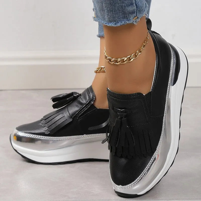 Women's black and white platform casual shoes with tassel detail and a muffin wedge heel