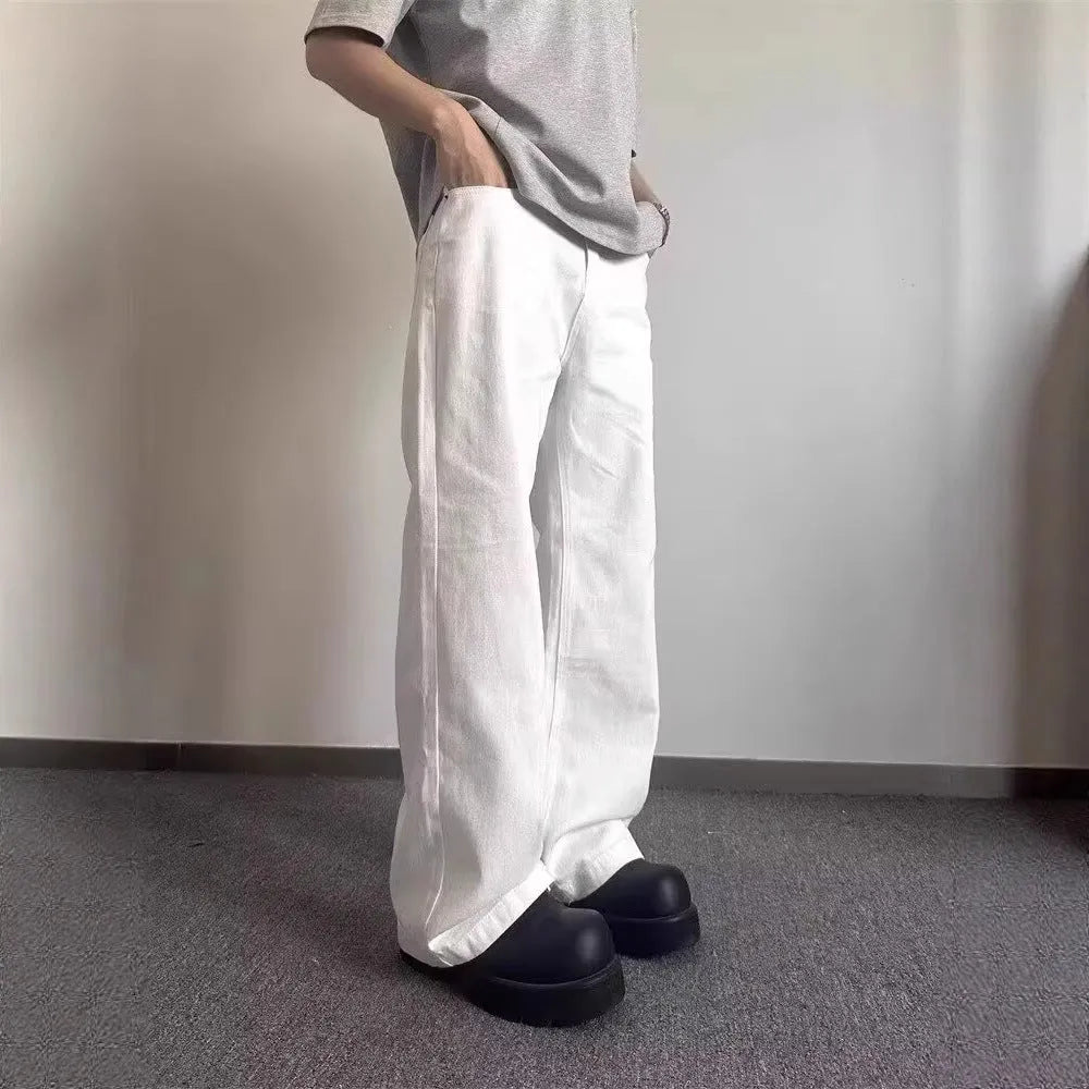 Men's white straight-leg cotton jeans with a wide-leg opening and zipper fly.