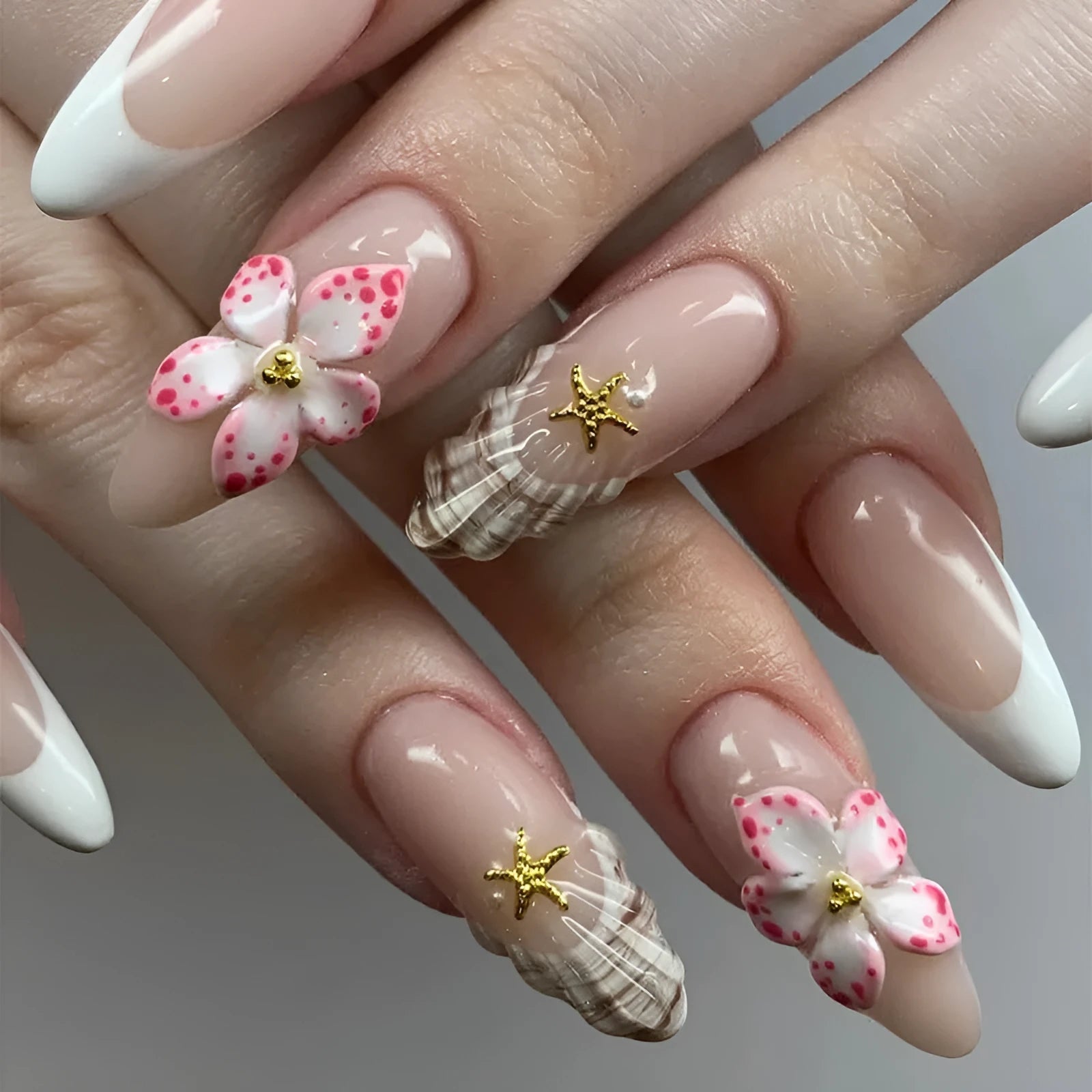 One pair of French style plastic false nails with a simple floral rock design and a bottle of nail glue.