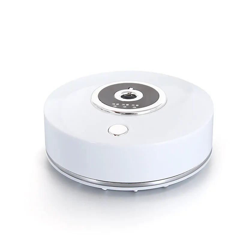 USB-powered plastic car aromatherapy spray machine in black, grey, or white on a car dashboard.