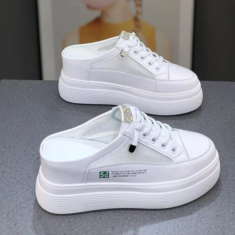 White women's platform trainers with mesh panels and a round toe on a rubber sole.