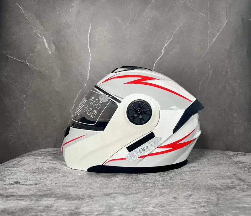 Matte black full face motorcycle helmet with integrated battery visor on a stand