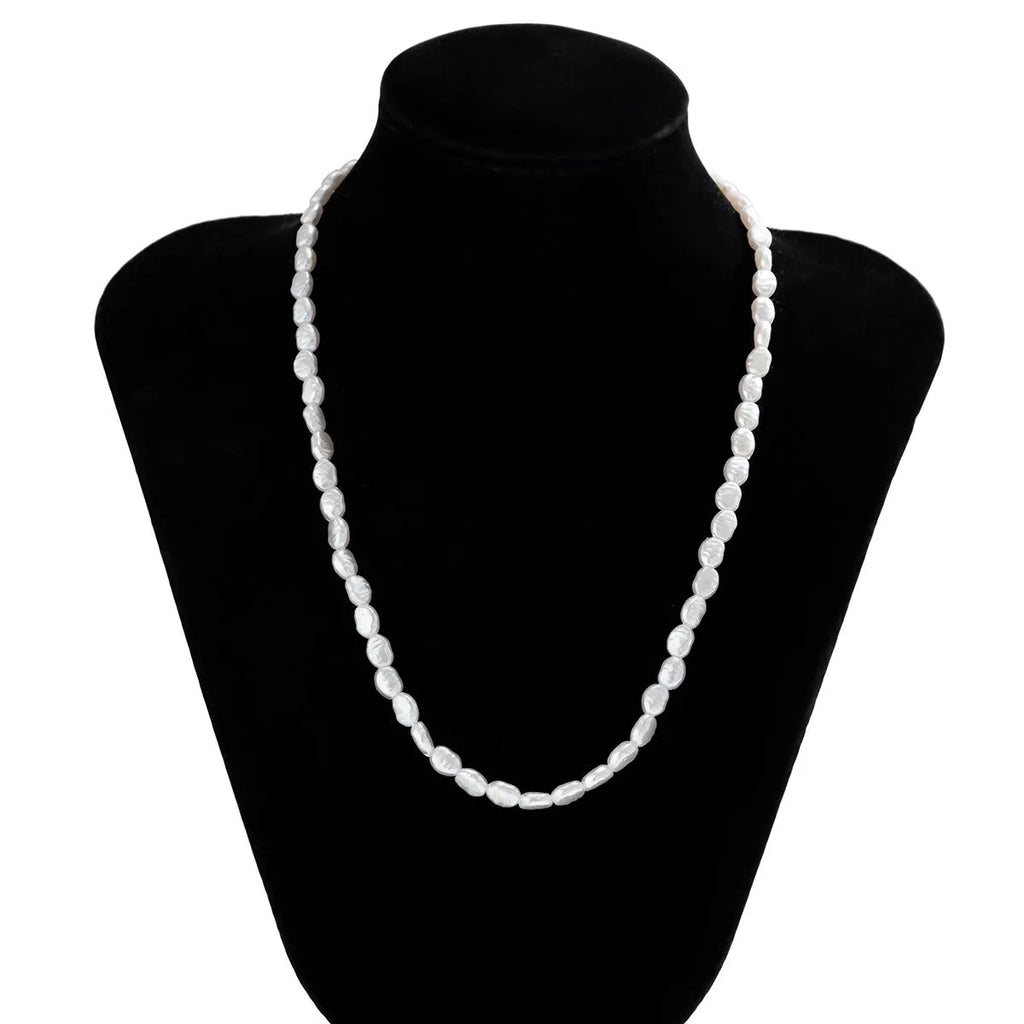 White U-shaped imitation pearl men's necklace with a shellfish pendant on a model.