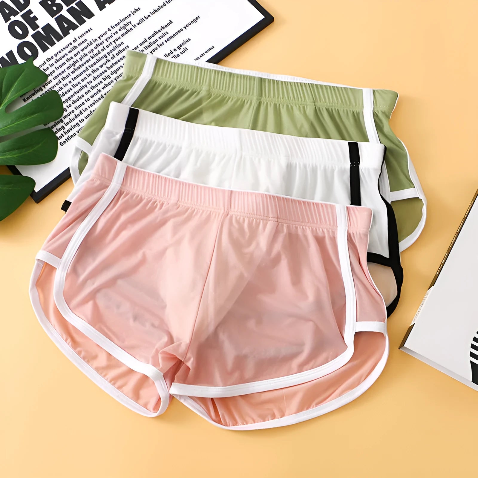 Men's black ice silk low waist sports boxers with mesh detail on a plain background.