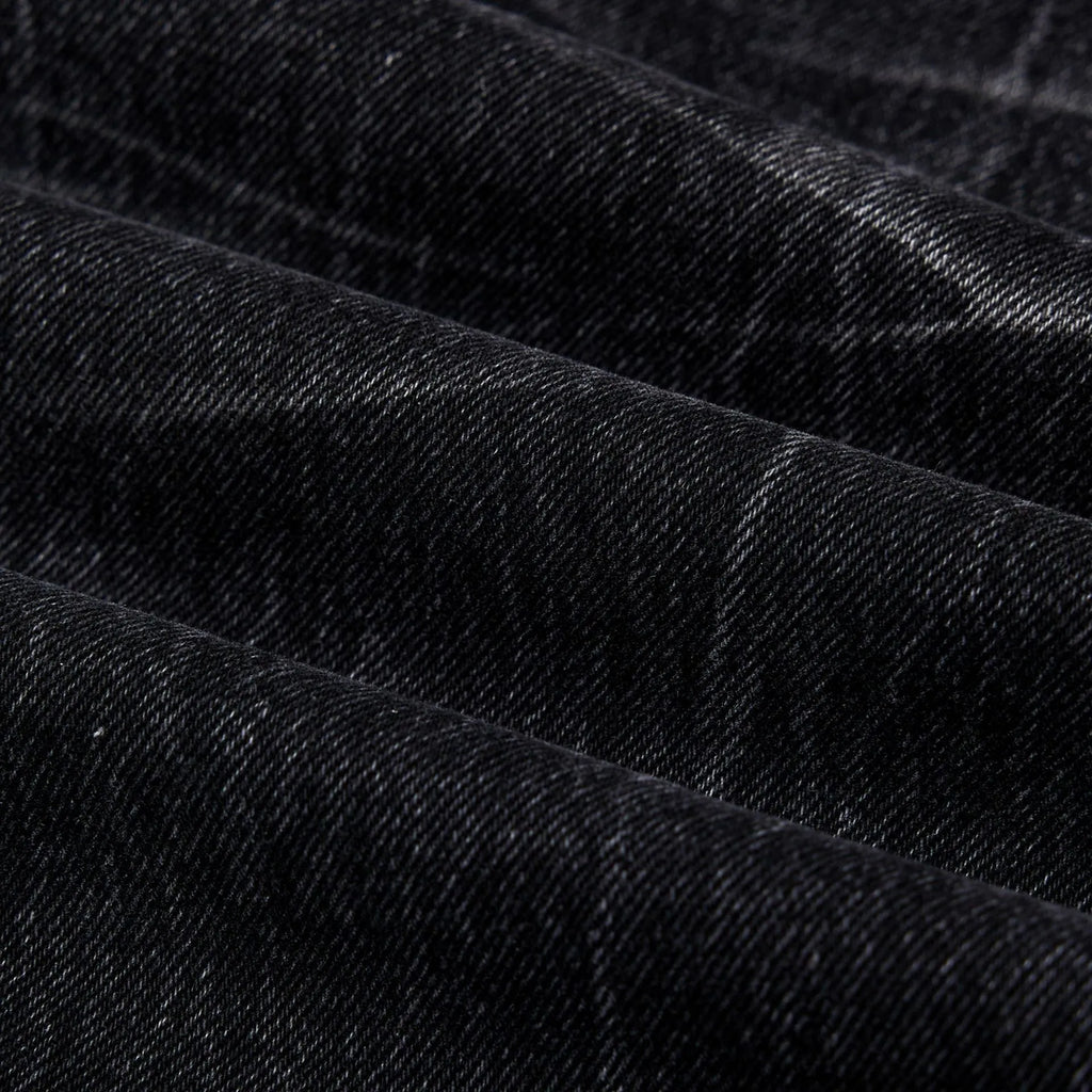 Men's straight-leg black jeans showing an American washed finish with a lightning crack pattern on the legs.