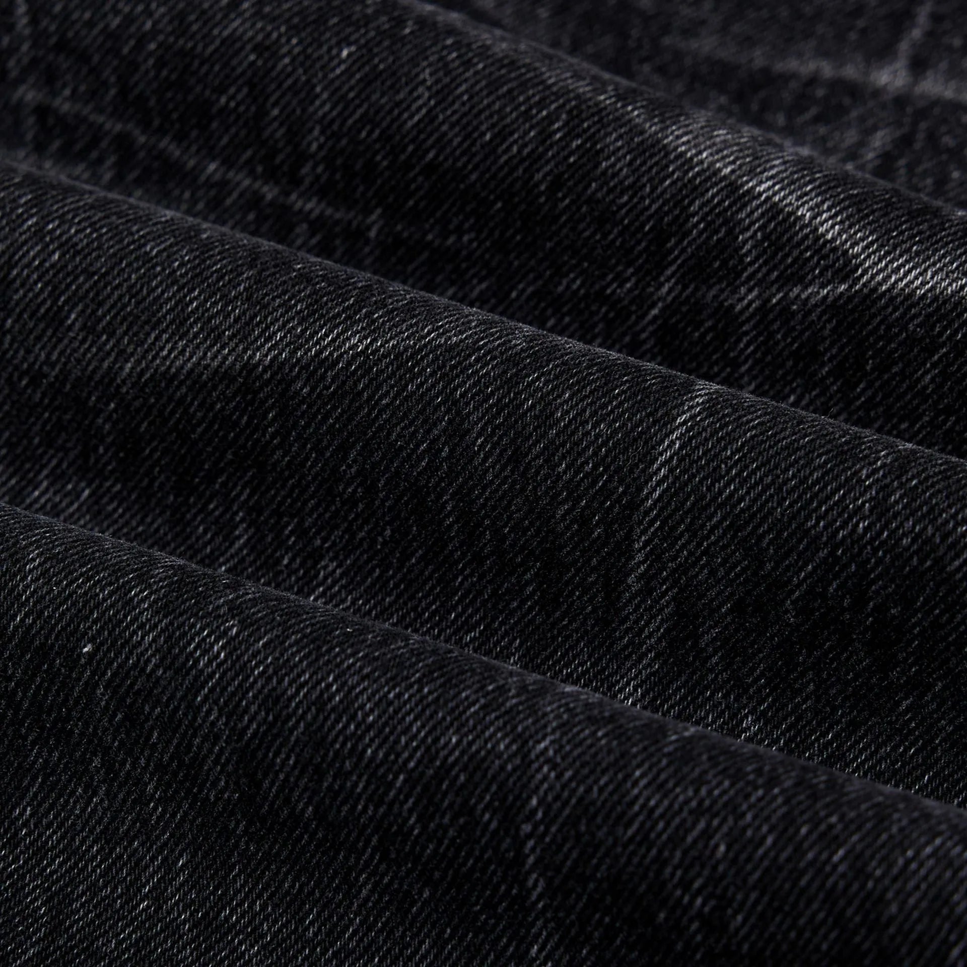 Men's straight-leg black jeans showing an American washed finish with a lightning crack pattern on the legs.