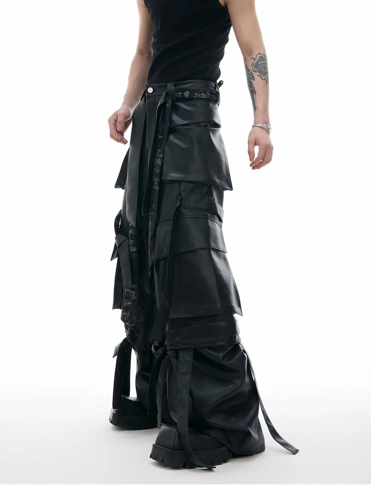 Black loose fit trousers with multi-pocket stitching and ribbon leather detailing on heavy composite fabric