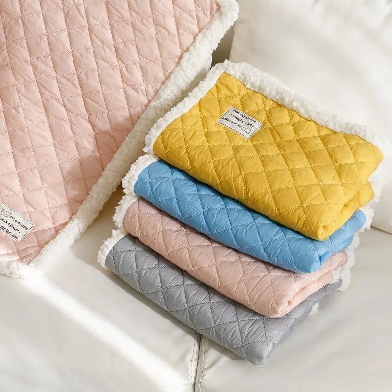 Quilted terry cloth cat blanket in blue, shown alongside pink, yellow, and grey colour options.