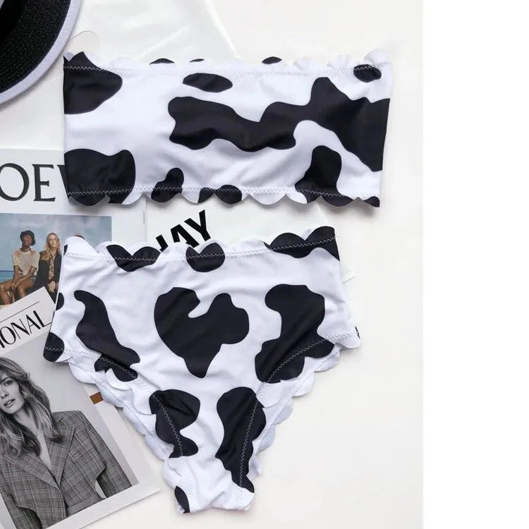 Women's black and white cow print bikini swimsuit with wrapped breast design on display