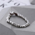 Women's handmade silver bracelet with wooden irregular square design on elasticated band