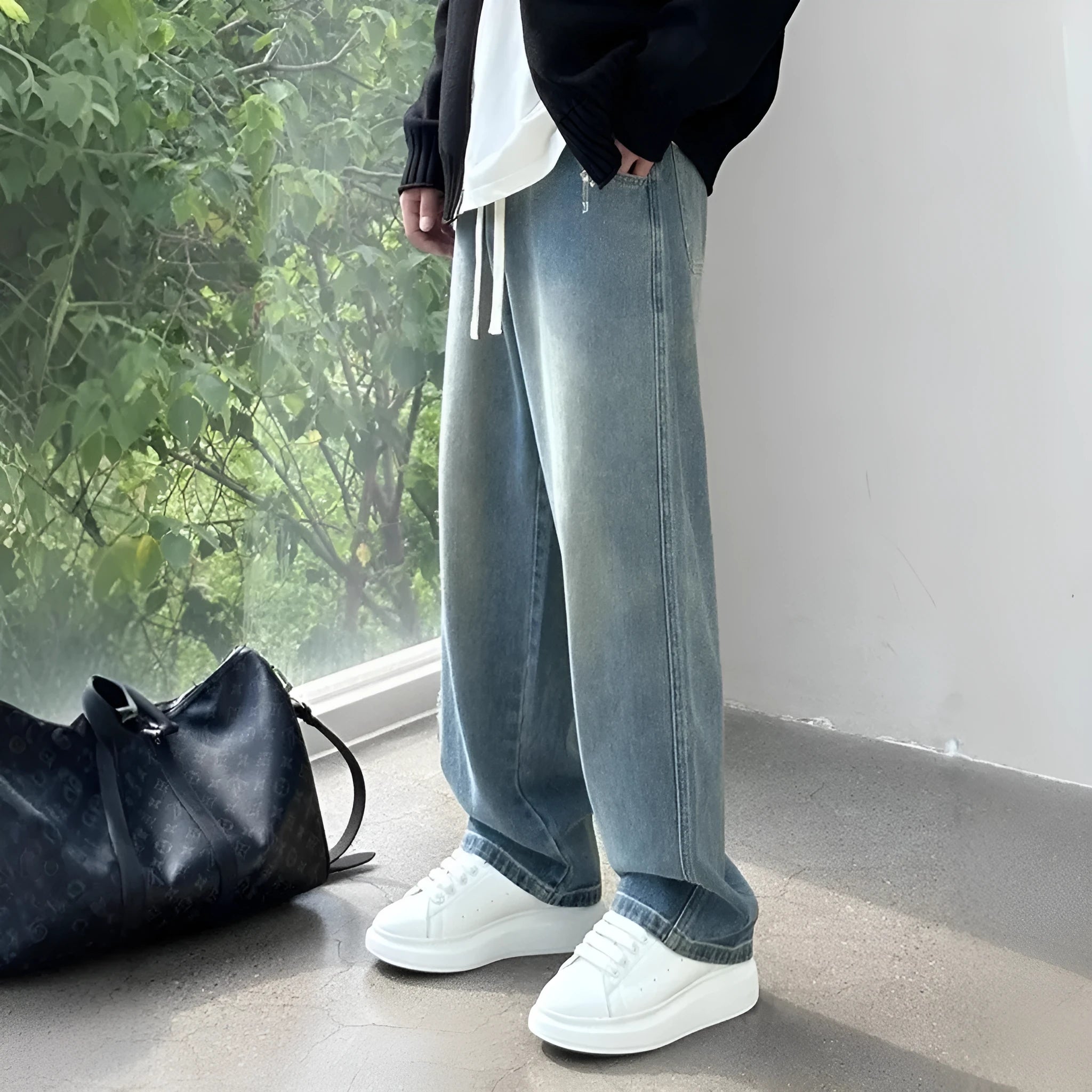 Men's loose fit straight leg denim trousers in blue and black with drawstring waist closure