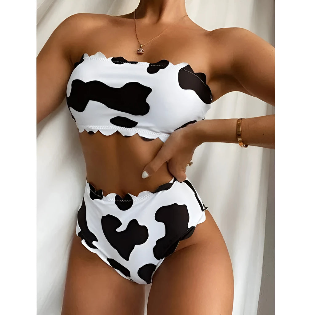 Women's black and white cow print bikini swimsuit with wrapped breast design on display