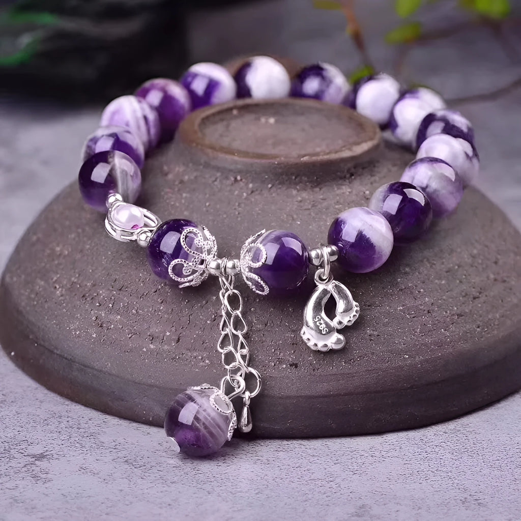 Natural amethyst bracelet with 10mm round beads on a woman's wrist.