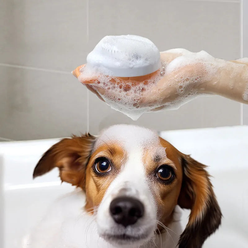 Orange dog bath brush with shampoo dispenser and soft TPR bristles on a curved pumpkin-shaped handle.