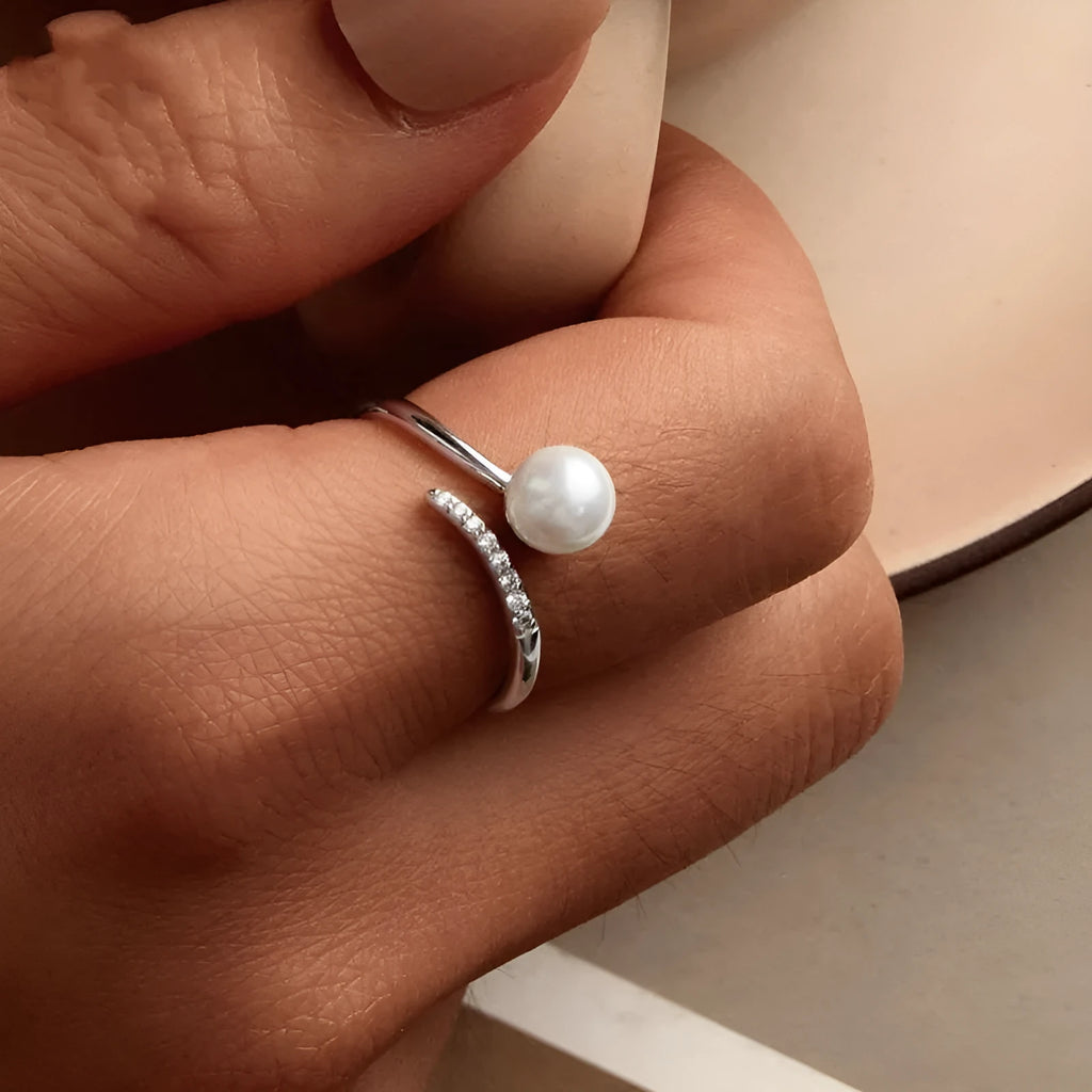 Women's S925 sterling silver adjustable ring with a natural pearl on an open loop.