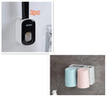 Black wall-mounted automatic toothpaste holder with toothbrush storage and suction cup mounting