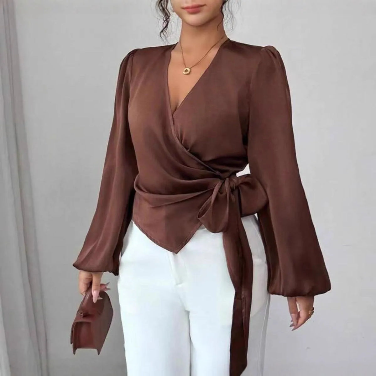 Brown long-sleeved waist-cinching shirt with ribbon detail on a female model
