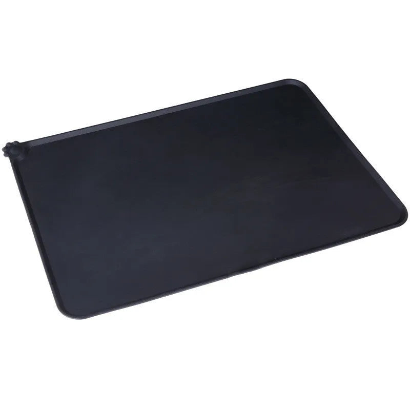 Black silicone dog food mat measuring 47 by 30 centimetres with non-slip surface and raised edges.