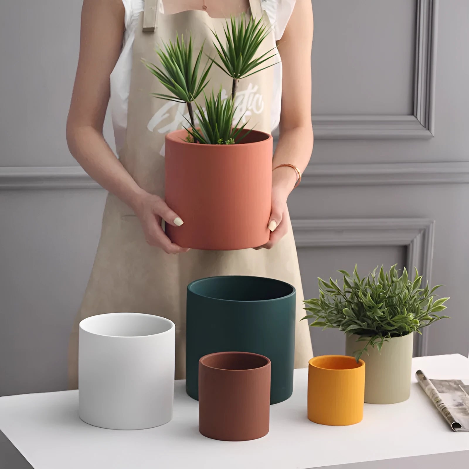 Cylindrical Nordic style ceramic succulent planter with drainage hole on wooden table