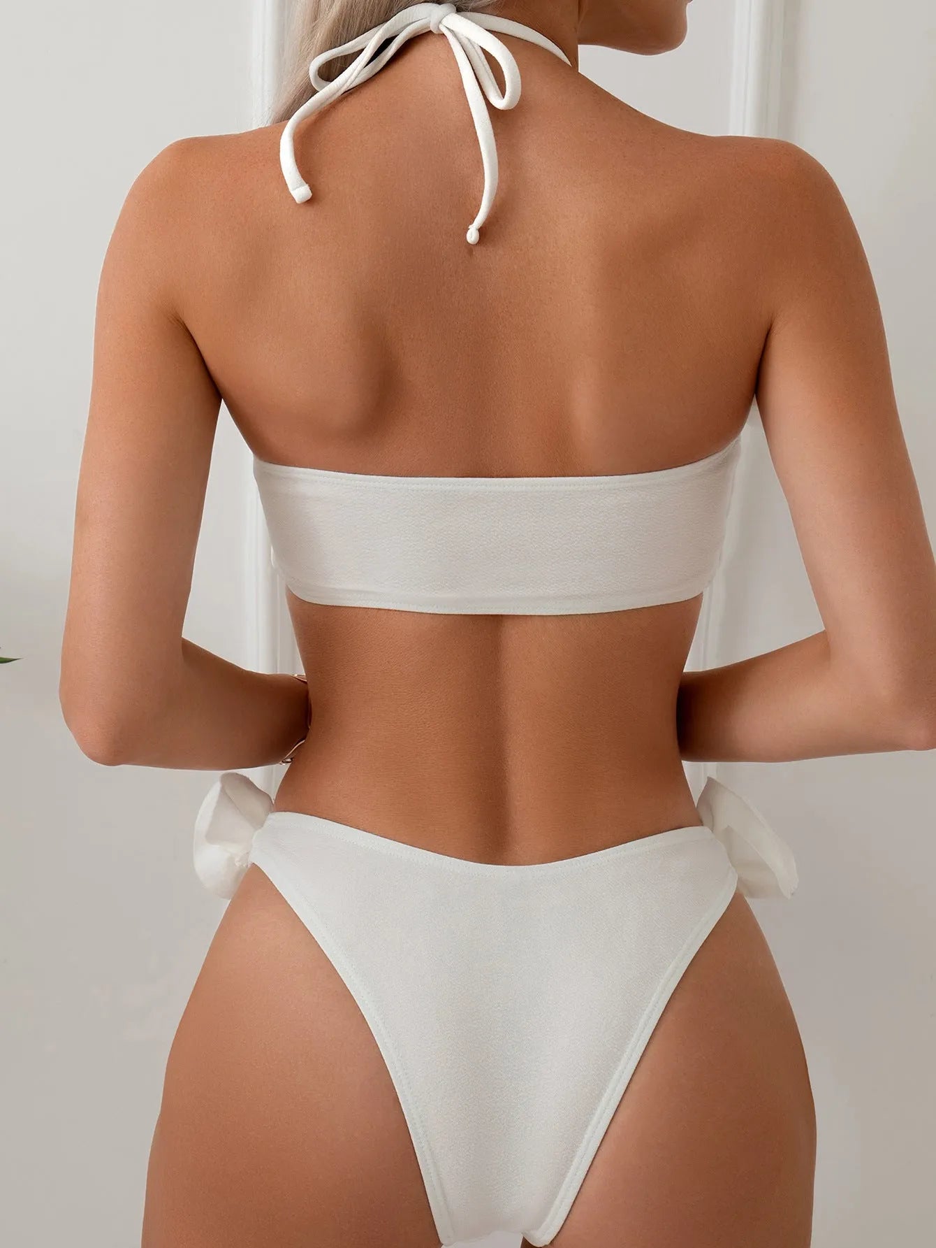 White women's halter lace-up swimsuit with three-dimensional floral design and briefs